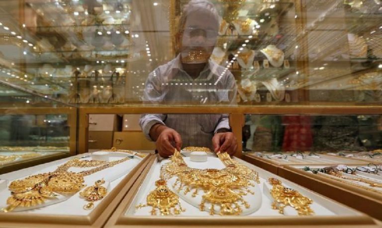 A salesman arranges a gold necklace in a display case inside a jewellery showroom on the occasion of Akshaya Tritiya in Kolkata